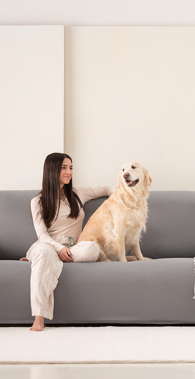 Jonge vrouw met hond op een bank met een aansluitende bankhoes